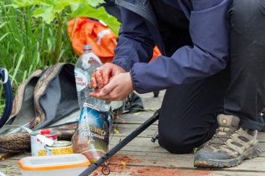 Rusya, Pushkino, 16.06.2020. Balıkçı oltaya balık yemi takar. Spor balıkçılığı için ekipman hazırlığı. Sadece editör kullanımı