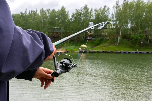 Fiskespö Männens Händer Fiskare Vänder Snurrande Rulle Bakgrunden Damm — Stockfoto