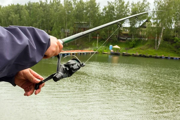 Fiskespö Männens Händer Fiskare Vänder Snurrande Rulle Bakgrunden Damm — Stockfoto