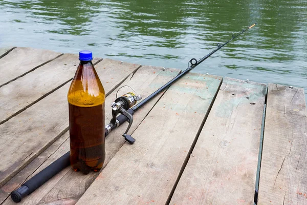 ビールと釣竿は木製の桟橋にある 釣りをしながらアルコール依存症や飲酒 — ストック写真