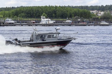 Rusya, Mytishchi, 12.06.2020. Tekne su kanalında yüzüyor. Kıç deliğinden su yüzeyinde izler bırakıyor. Tekne gezileri ve geziler. Su rekreasyonu konsepti. Sadece editör kullanımı.