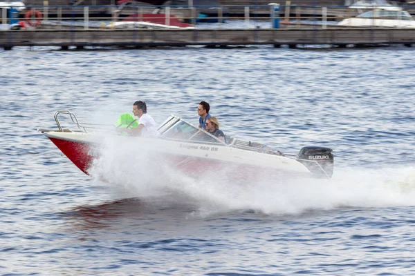 Rusya, Moskova, 13.06.2020. Su kanalında yüzen kırmızı tekne. Sprey sineklerden, su yüzeyinde iz bırakarak. Tekne gezileri ve geziler. Su rekreasyonu konsepti. Sadece editör kullanımı.