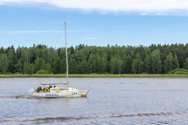 Rusya, Mytishchi, 17.07.2020. Beyaz bir yelkenli yatı, Moskova kanalı boyunca yeşil orman ve mavi gökyüzünün arka planına doğru ilerliyor. Sadece editör kullanımı