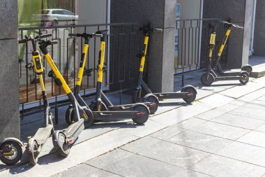 Rusya, Saint Petersburg, 08.08.2020. Duvarın yanındaki kiralık istasyonda birkaç sarı scooter. Mobiletlerin kirası ödenmiş. Modern ulaşım. Çevre taşımacılığı, trafik sıkışıklıklarına karşı mücadele, ulaşım altyapısı.