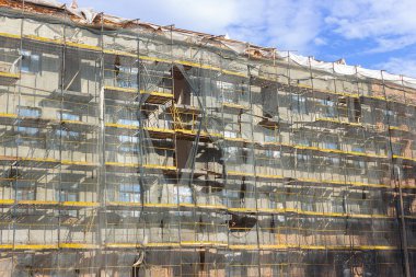 Binanın restorasyonu ve iskele tozdan ve molozlardan korunmak için kumaşla kaplandı. İnşaatçıların işi binaları düzgün bir şekilde muhafaza etmektir..