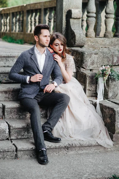 Hermosa pareja de boda fuera del castillo en las escaleras —  Fotos de Stock