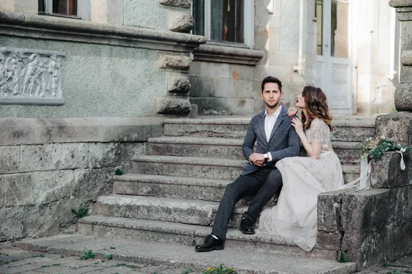 Hermosa pareja de boda fuera del castillo en las escaleras —  Fotos de Stock