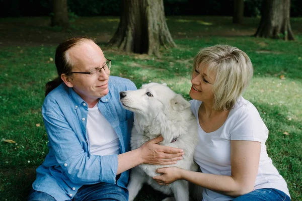 Volwassen Paar Zittend Het Gras Met Een Witte Hash — Stockfoto