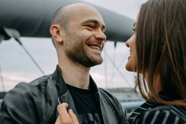 Başlarını aşık dokunmadan bir göl kenarında oturan genç bir çift görünümünü arka. Açık havada bir bardak şarap ile bir göl kenarında oturan bir tarihte aşık çift.