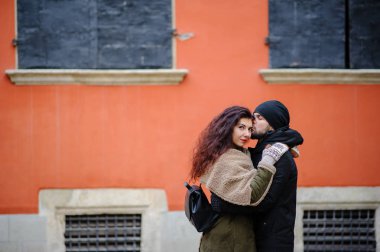 Young happy couple of lovers at beginning of love story - Handsome man whispers soft kisses in beautiful woman ear - Fall fashion concept with boyfriend and girlfriend on a cold vintage filtered look