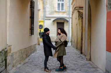 Sevgi dolu genç çift sahilde sonbaharda yürümek.