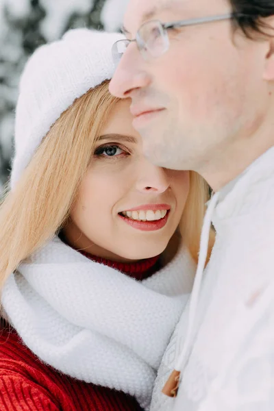 Giovane uomo con borsa abbraccia la sua ragazza nella foresta invernale — Foto Stock