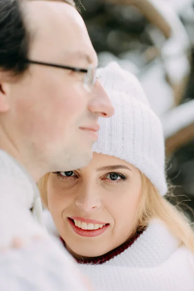Junger Mann mit Tasche umarmt seine Freundin im Winterwald — Stockfoto