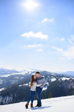 Seven çift birlikte açık karda oynarken. Dağlarda kış tatili. Erkek ve kadın hafta sonları eğleniyor örme giyim.