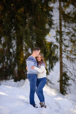 Büyüleyici çift birbirlerine kış ormanda sarılma.