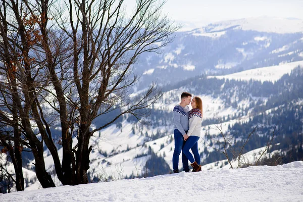 Loving couple playing together in snow outdoor. Winter holidays in mountains. Man and woman wearing knitted clothing having fun on weekends. — Stock Photo, Image