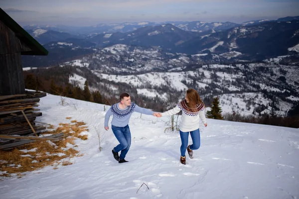 Pessoas se divertindo e correndo em montanhas no fundo de altos picos cobertos de neve — Fotografia de Stock