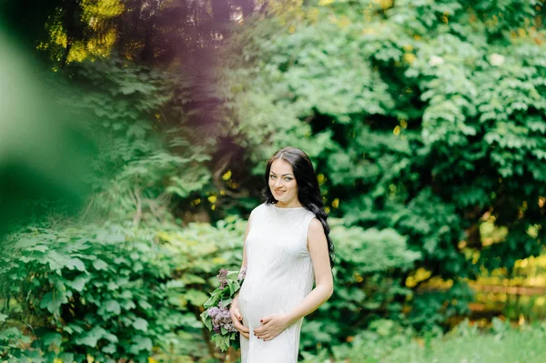 花輪や野生の花 o のブーケで幸せな妊娠中の女性 — ストック写真