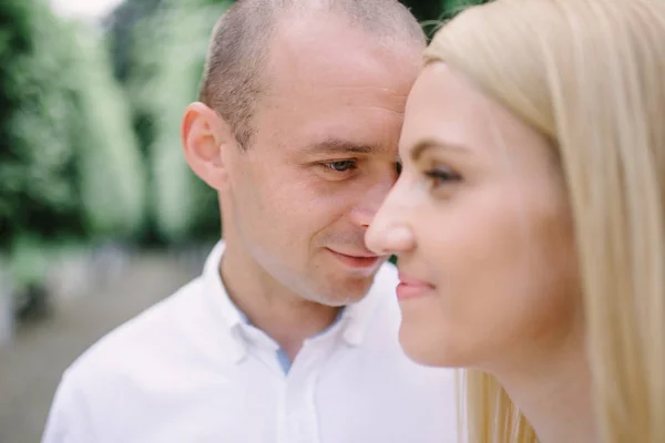 Testa girato felice millenario giovane uomo e donna abbracciare al chiuso. Ritratto da vicino sorridente marito e moglie cavalcata guardando la macchina fotografica ridere. Incontri e romantico concetto di relazione — Foto Stock