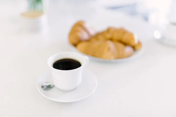 Petit déjeuner avec des petits pains frais avec café et lait sur table blanche. Croissant doré . — Photo