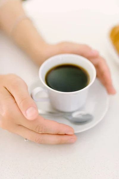 Mannenhand houden mok koffie op houten tafel. — Stockfoto