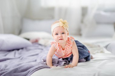 Sevimli, küçük beyaz bir kızın yatakta uzanıp gülümsediğini gördüm. Doğrudan kameraya bakıyor..