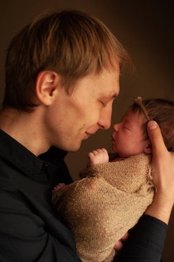 Baba sevgi dolu yeni doğmuş kızı tutarak