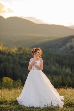 Gelin gün batımında dağların arka planında poz veriyor..