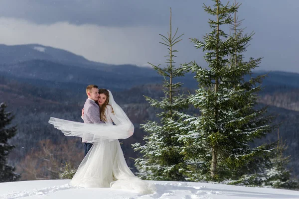 Groom Abraça Sua Noiva Contra Pano Fundo Montanhas Cobertas Neve — Fotografia de Stock