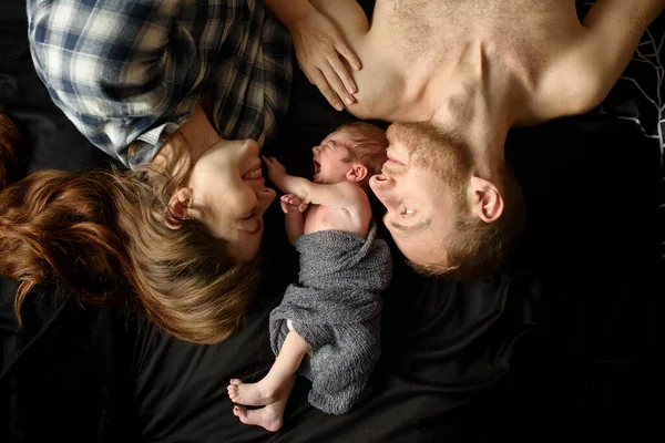 Anne Baba Siyah Arka Planda Yeni Doğan Oğullarının Yanındalar — Stok fotoğraf