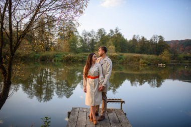 Romantik genç bir çift gölün yakınındaki bir iskelede duruyor. Düş.