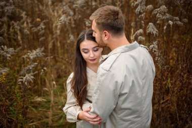 Güz parkında vakit geçirirken birbirine sarılan genç ve güzel bir çiftin yakınlaşması.