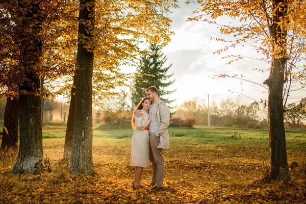 在一个阳光明媚的秋日 年轻夫妇手牵手穿过公园 — 图库照片