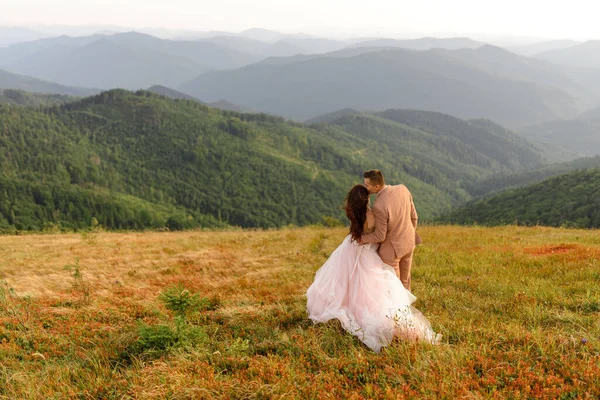 Noivo Beija Noiva Testa Pôr Sol Foto Casamento Fundo Montanhas — Fotografia de Stock