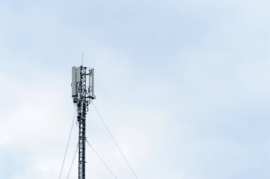 Gökyüzünün arka planında mobil operatör antenleri olan kule
