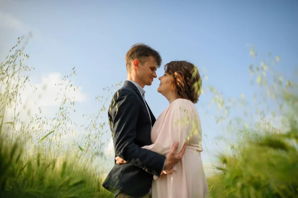 Adult couple in a green wheat field.