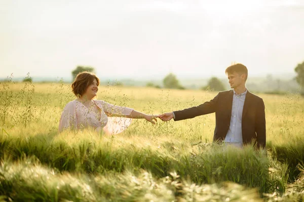 Adult couple in a green wheat field.