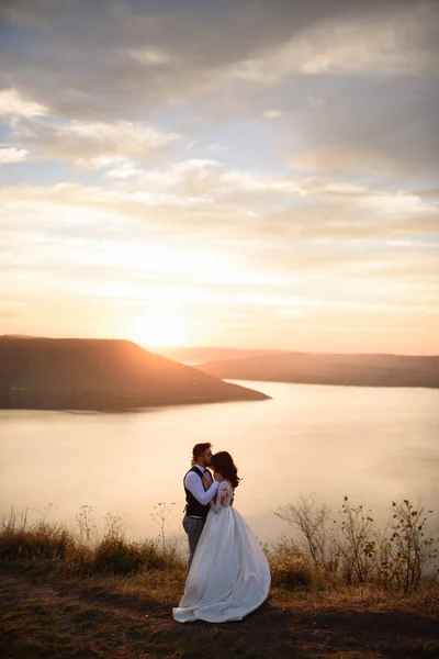 Noiva Noivo Estão Abraçando Fundo Lago Durante Pôr Sol — Fotografia de Stock
