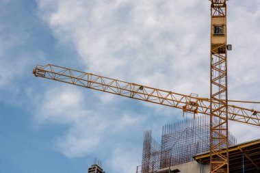 Mavi gökyüzüne karşı vinç ve inşaat alanı