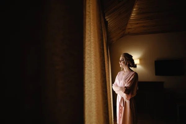 Gyönyörű Szőke Lány Rózsaszín Fürdőköpenyben Néz Ablakon — Stock Fotó