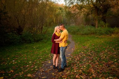 Erkek ve kadın sonbahar parkında sarılıyorlar..