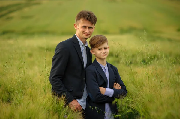 Father and son in a green wheat field