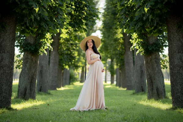 Вагітна Жінка Позує Бежевій Сукні Фоні Зелених Дерев — стокове фото