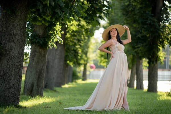Вагітна Жінка Позує Бежевій Сукні Фоні Зелених Дерев — стокове фото