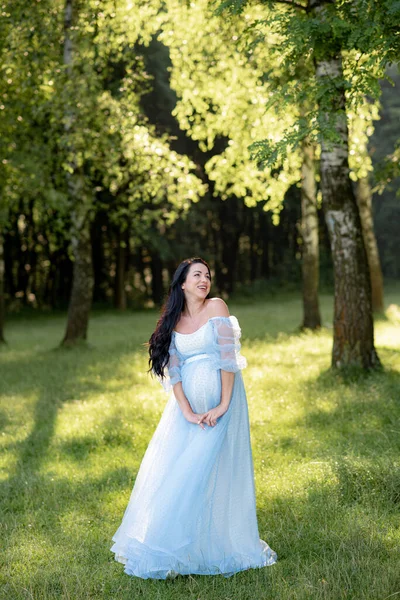 Zwangere Vrouw Poseren Een Blauwe Jurk Een Achtergrond Van Groene — Stockfoto