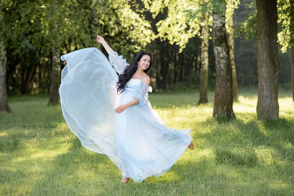 Беременная Женщина Позирует Синем Платье Фоне Зеленых Деревьев — стоковое фото