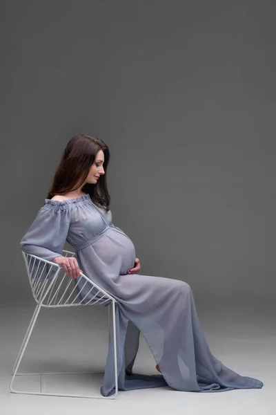 Mujer Embarazada Joven Vestido Sienta Una Silla Estudio — Foto de Stock