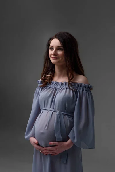 Una Joven Embarazada Con Vestido Está Pie Sobre Fondo Gris —  Fotos de Stock