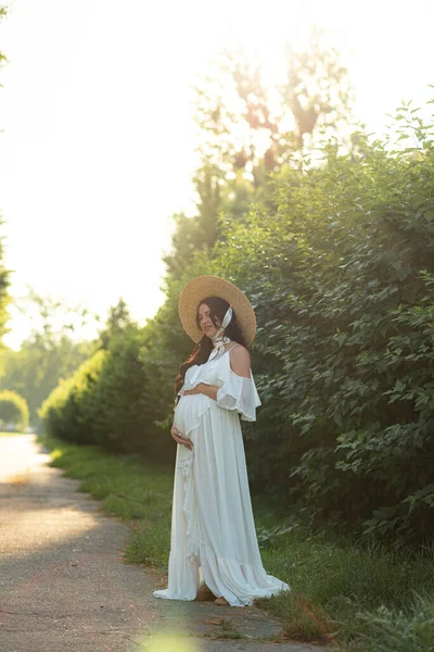 Doğanın Arka Planında Beyaz Bir Elbise Giymiş Hamile Bir Kadın — Stok fotoğraf