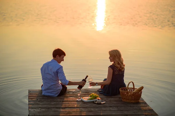 湖の近くの桟橋でピクニックをしている男女 — ストック写真